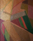 Close up of a vintage abstract oil painting of a female figure painted using geometric shapes in warm ochre colours, reminiscent of a cubist or modernist style.