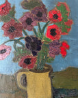 Close up of a framed, vintage artwork of red flowers on a teal blue background.
