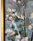 Close up of a framed vintage oil painting of white apple blossom flowers.