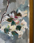 Close up of a framed vintage oil painting of white apple blossom flowers.