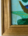 Close up of a framed, green & blue mixed media artwork with abstract design.