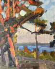 Close up of a framed, vintage oil painting of a landscape with trees and a body of water.