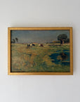 A framed vintage landscape oil painting depicting a grassy field with cows, a tree, and a small pond, housed in a gold-toned frame. Available at Hue.