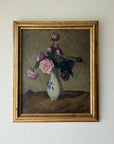 A framed vintage oil painting of pink roses in a white vase. The painting features a textured olive background, with the flowers in shades of pink and purple, and is enclosed in a distressed gold frame. Available at Hue.