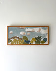 Framed abstract artwork with green, blue, and brown cloud shapes, available from hue