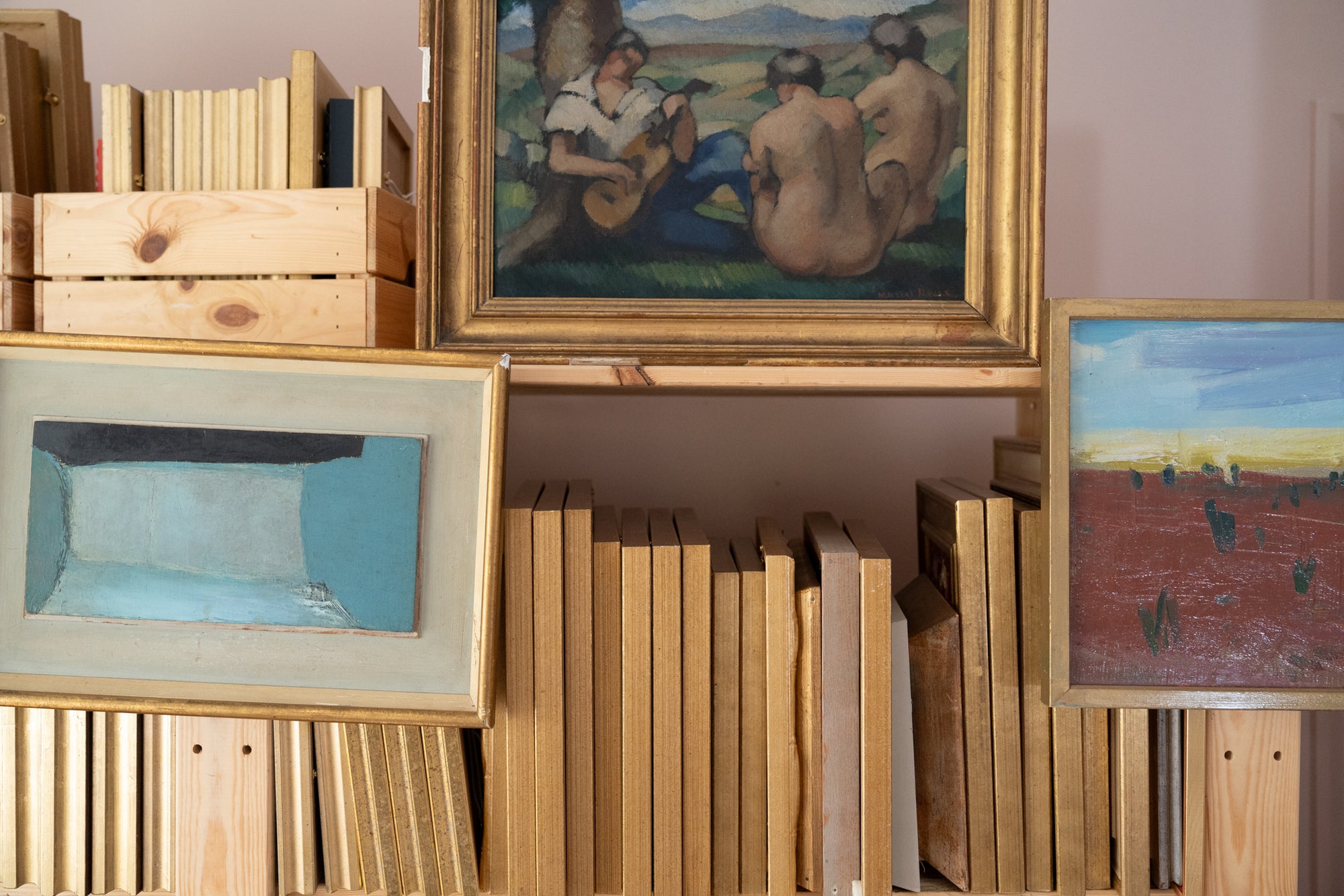 Collection of framed artworks and books on a shelf available from hue