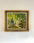 Framed painting of a street scene with trees and people in a vintage frame, available at Hue