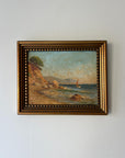 Framed vintage oil painting of a coastal scene with a sailboat. Available at Hue.