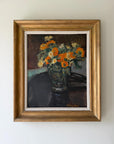 A framed vintage still life oil painting of a vibrant orange and yellow flower bouquet in a vase. Available at Hue.