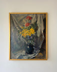 A framed vintage oil painting of red, yellow and blue flowers in a vase. Available at Hue.