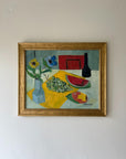 A framed vibrant vintage oil painting of a tabletop study with fruit and florals. Available at Hue.