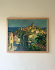A framed vintage landscape oil painting of a southern European hillside village in the sunlight Available at Hue.