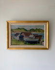 A framed vintage landscape painting of a coastal village with a boat. Available at Hue.