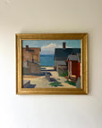 A framed vintage oil painting of a village harbour. Available at Hue.