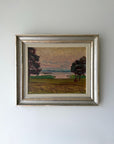 Framed vintage oil painting of a landscape with trees and an evening sky. Available at Hue.