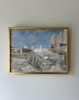 Framed vintage oil painting of a landscape with buildings and blue sky in a slim gilt frame, available at Hue.