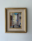 Framed vintage oil painting of an Italian street scene with people and laundry hanging. Available at Hue.