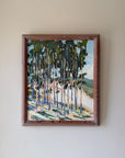 A framed vinatge landscape painting of a forest with tall trees, painted in green, blue, and beige tones. Available at Hue.