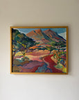 A framed vintage oil landscape painting featuring stylized mountains, trees, and a winding red path. Available at Hue.