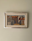 Framed vintage oil painting of a village scene with white, sunlit houses. Available at Hue.