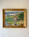 Framed vintage oil painting of a coastal landscape with wild greenery and a cottage. Available at Hue.