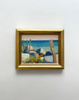 Framed vintage oil painting of a coastal scene with bright blue colours, available at Hue.
