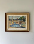 Framed vintage oil painting of a bridge over a river and a riverboat in a vintage frame, available at Hue.