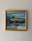A framed landscape painting with an abstract coastal scene, featuring blue, green, brown, and gold tones, housed in a gold frame. Available at Hue.