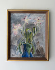 A framed vintage still life painting of pink and white flowers with green leaves in a blue vase, enclosed in a gold-toned wooden frame. Available at Hue.