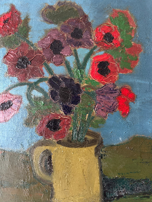Close up of a framed, vintage artwork of red flowers on a teal blue background.