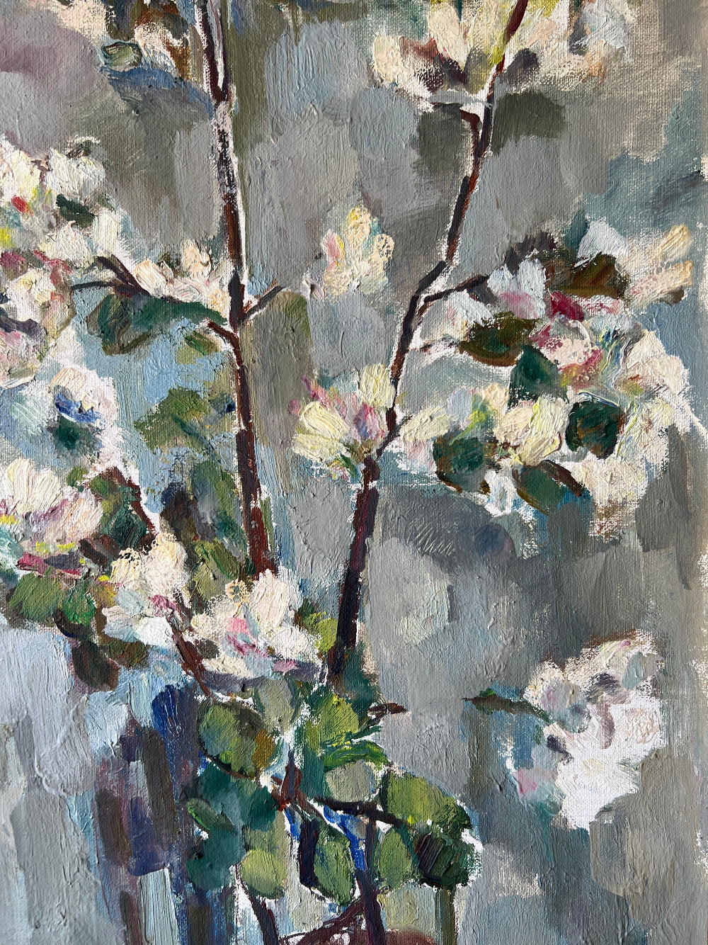 Close up of a framed vintage oil painting of white apple blossom flowers.
