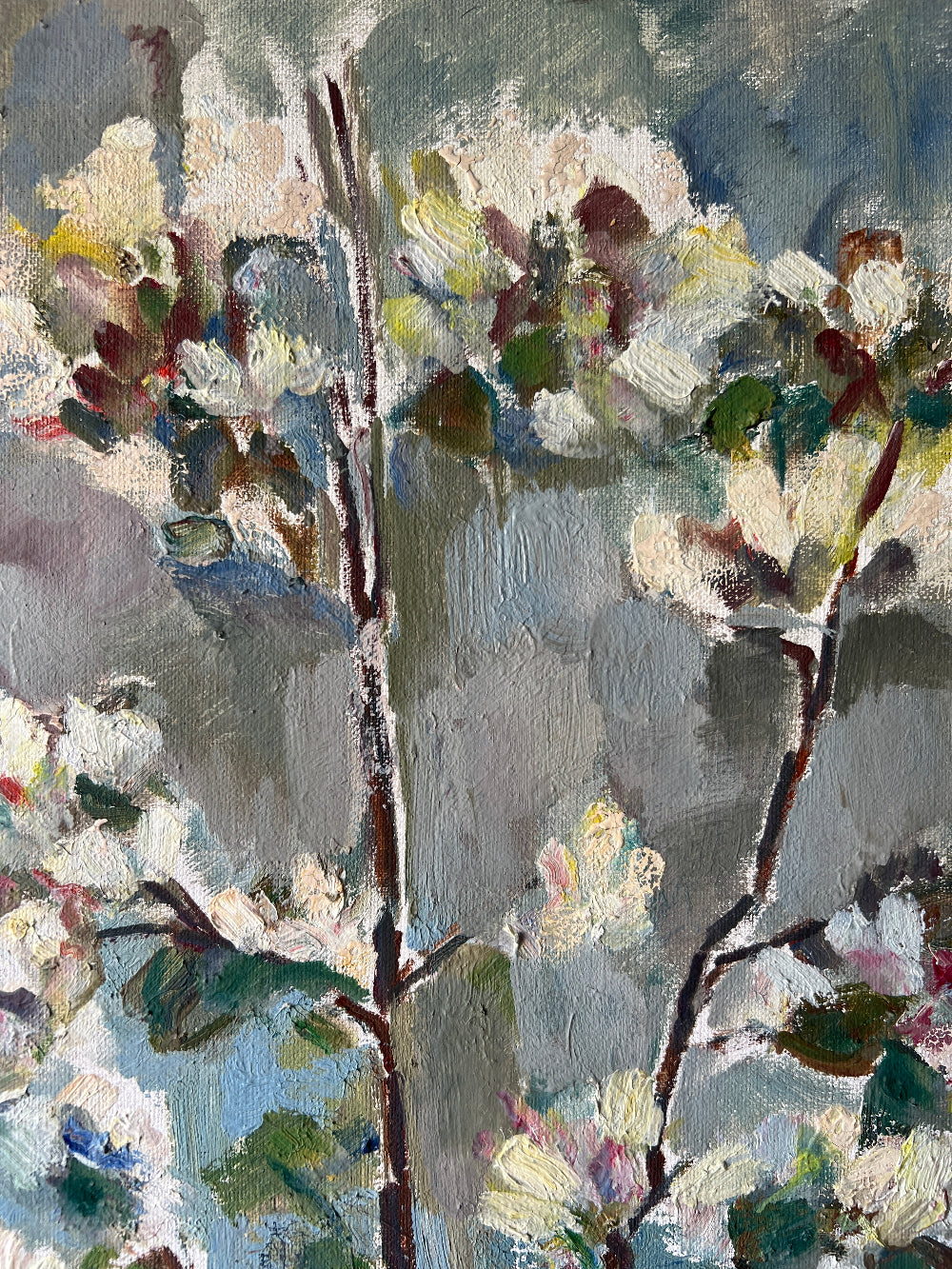 Close up of a framed vintage oil painting of white apple blossom flowers.
