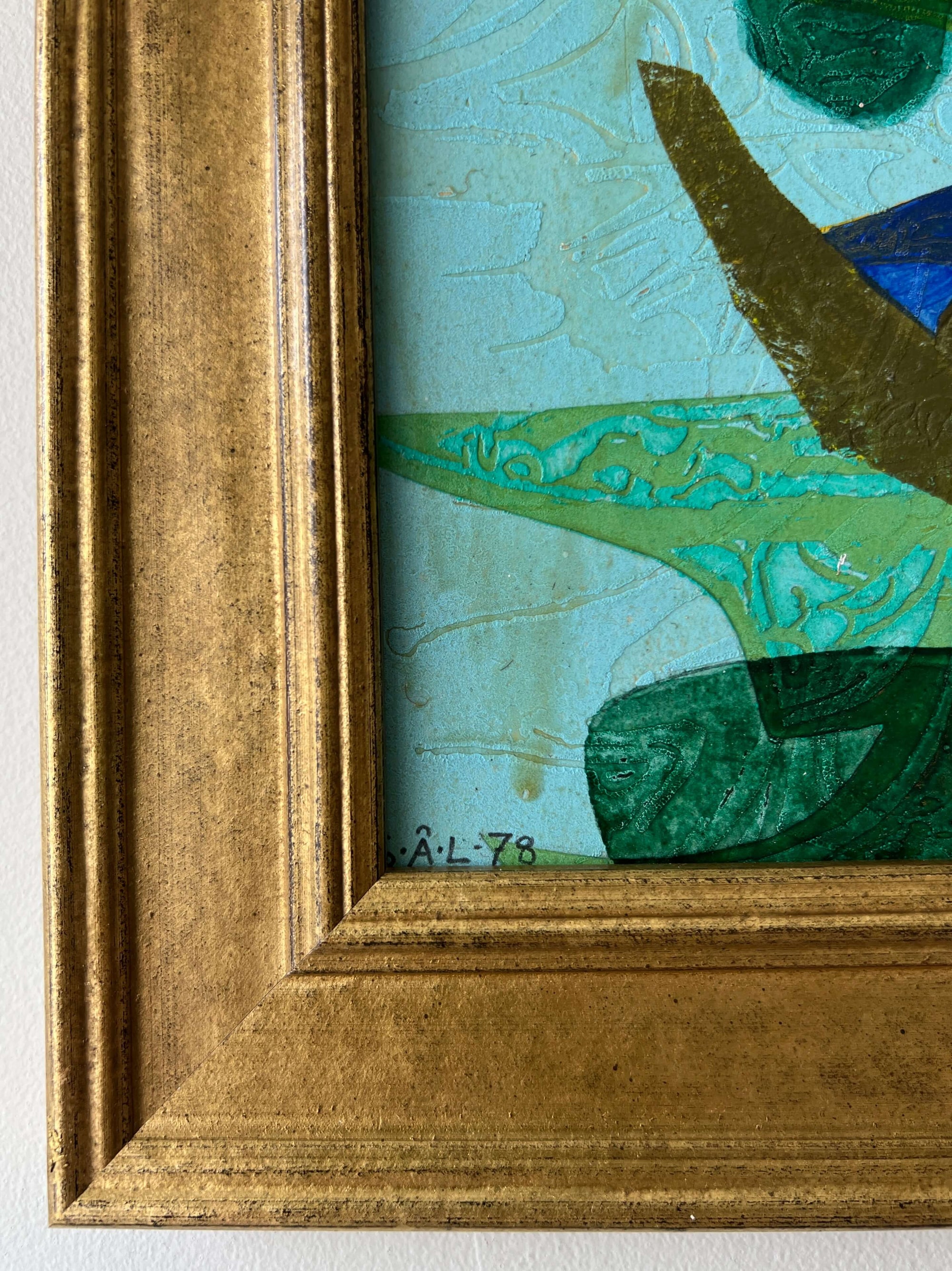 Close up of a framed, green & blue mixed media artwork with abstract design.