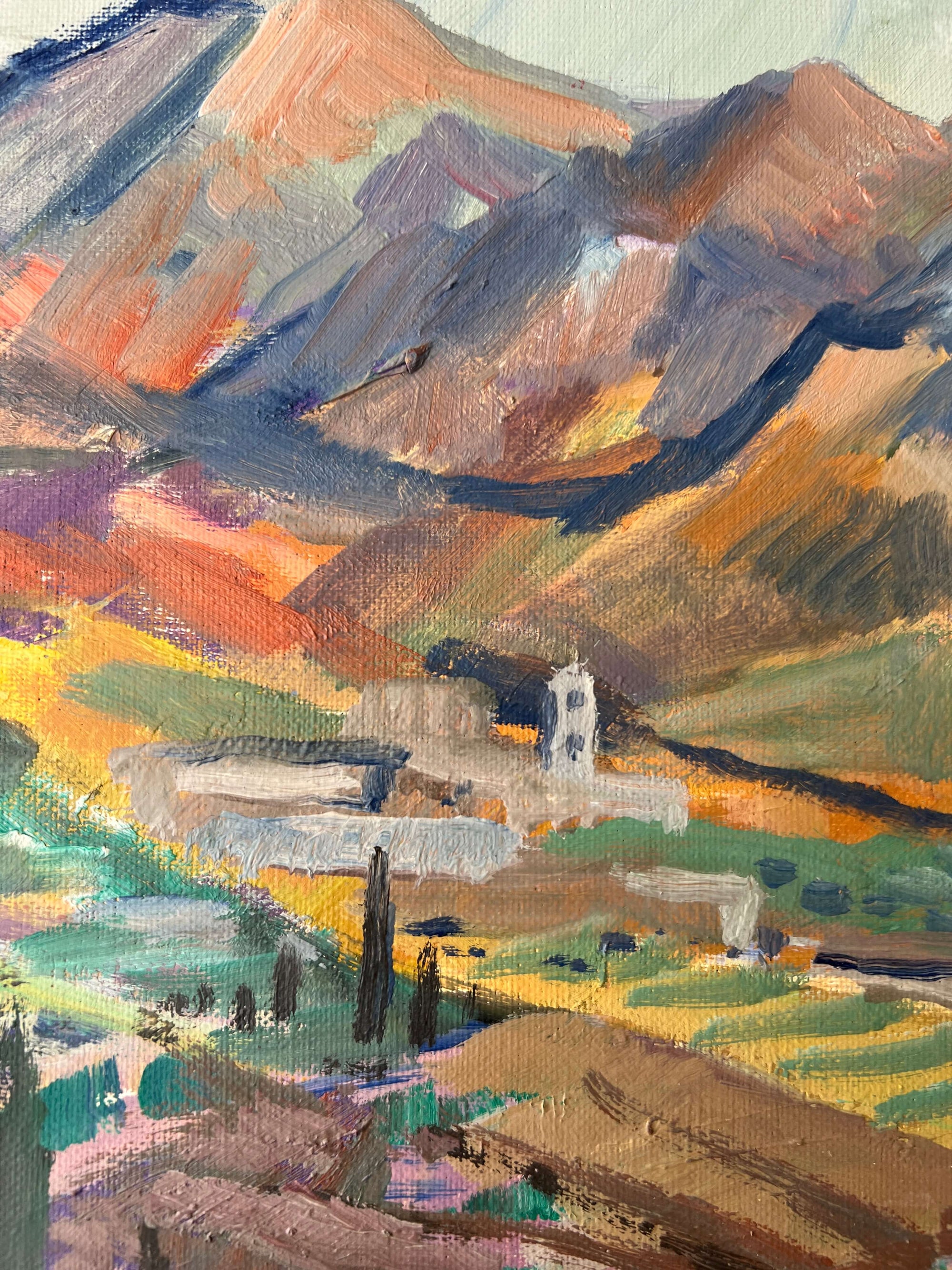 Close up of a framed, vintage oil painting on canvas of a mountainous coastal landscape with houses. Impressionist style.