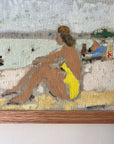 Close up of a framed artwork of a beach scene with figures