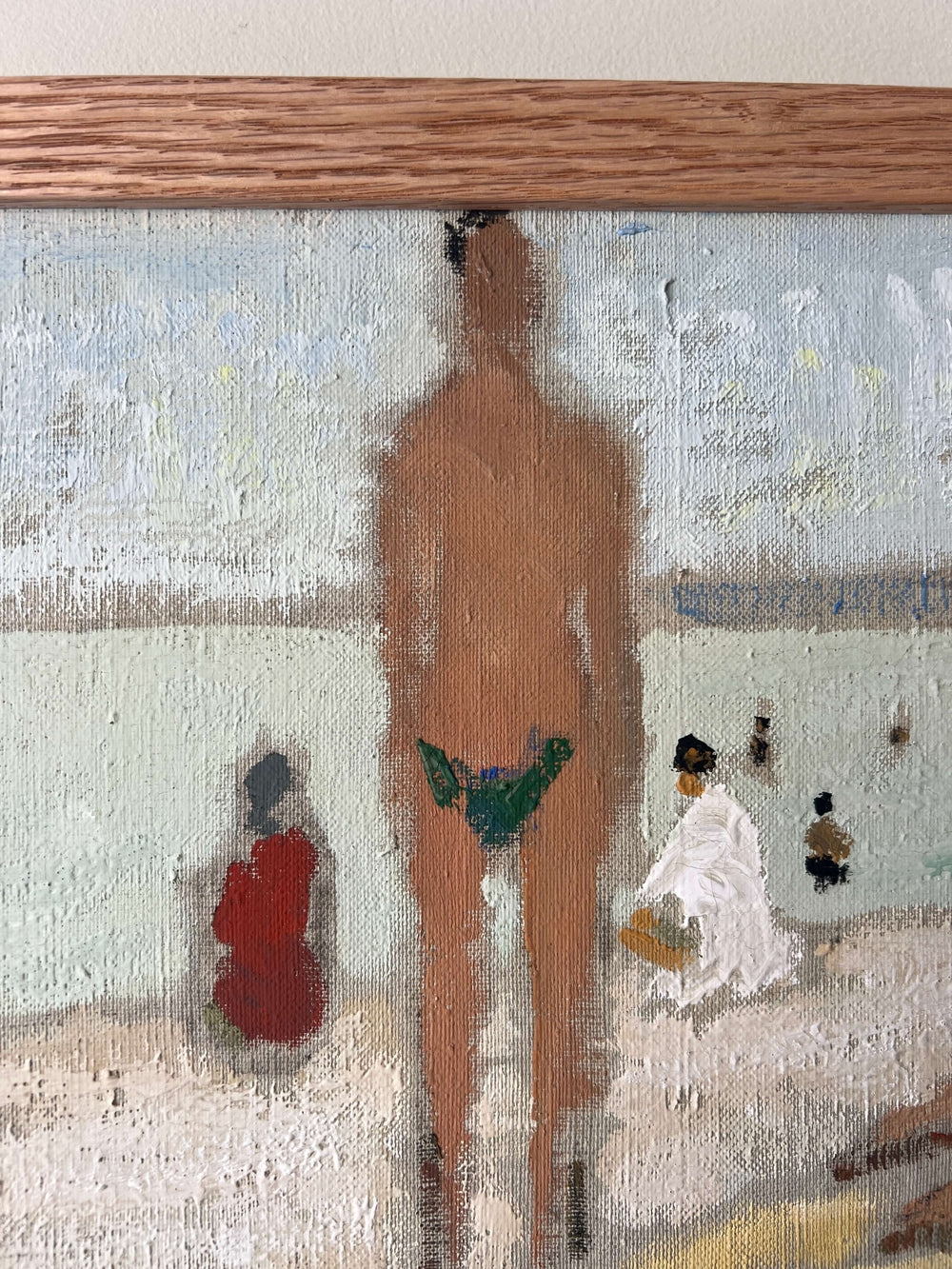 Close up of a framed artwork of a beach scene with figures