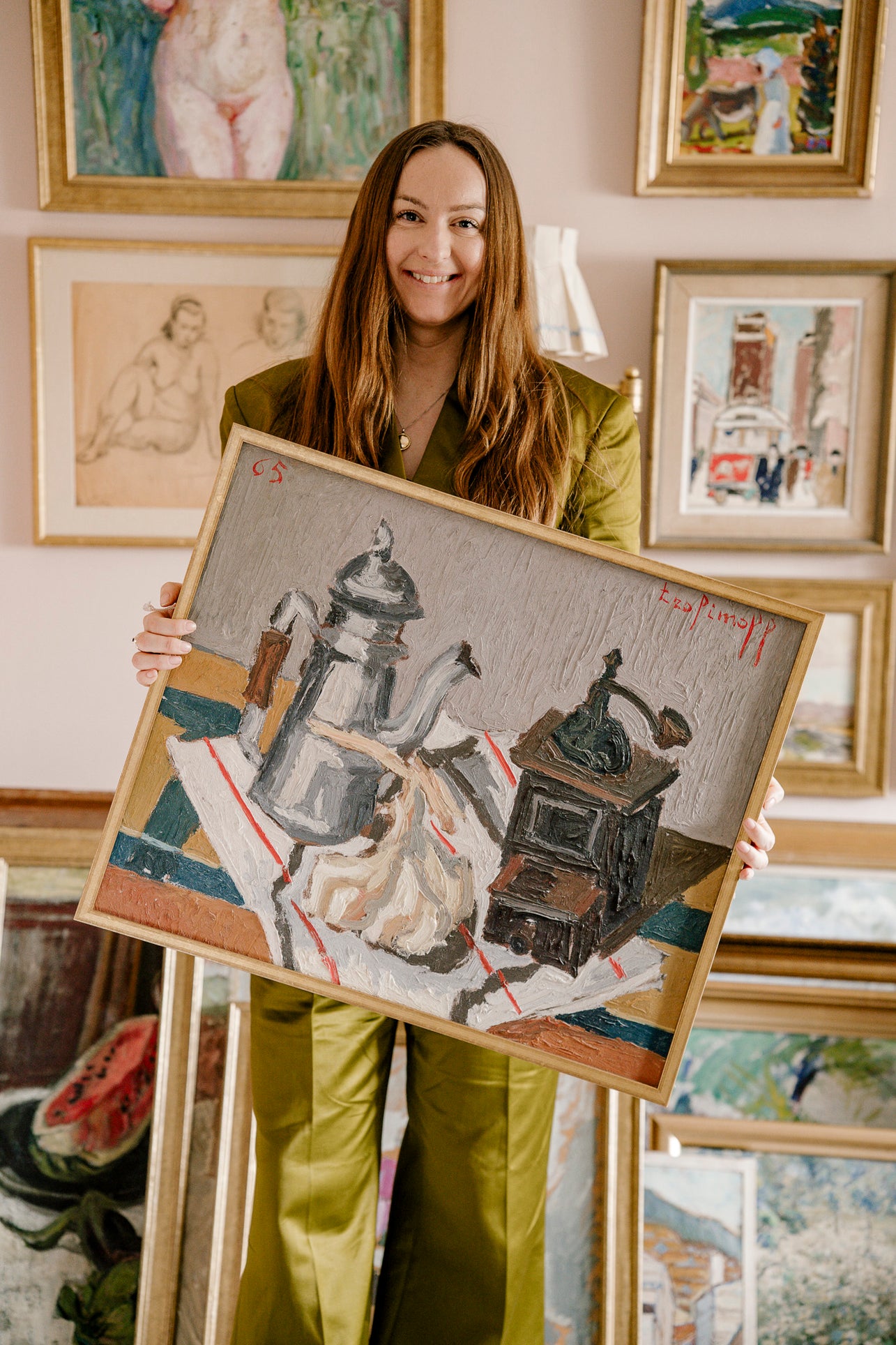 Woman holding a framed vintage artwork in an art studio