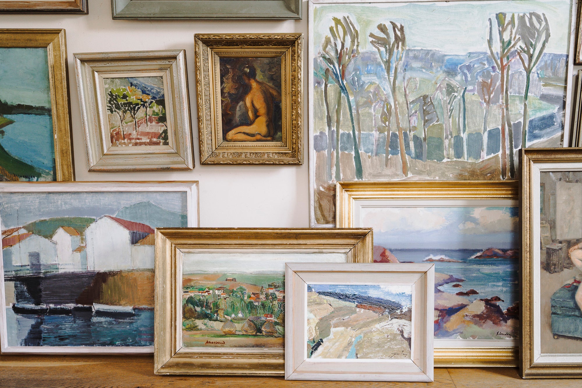 Collection of framed vintage paintings on a wall