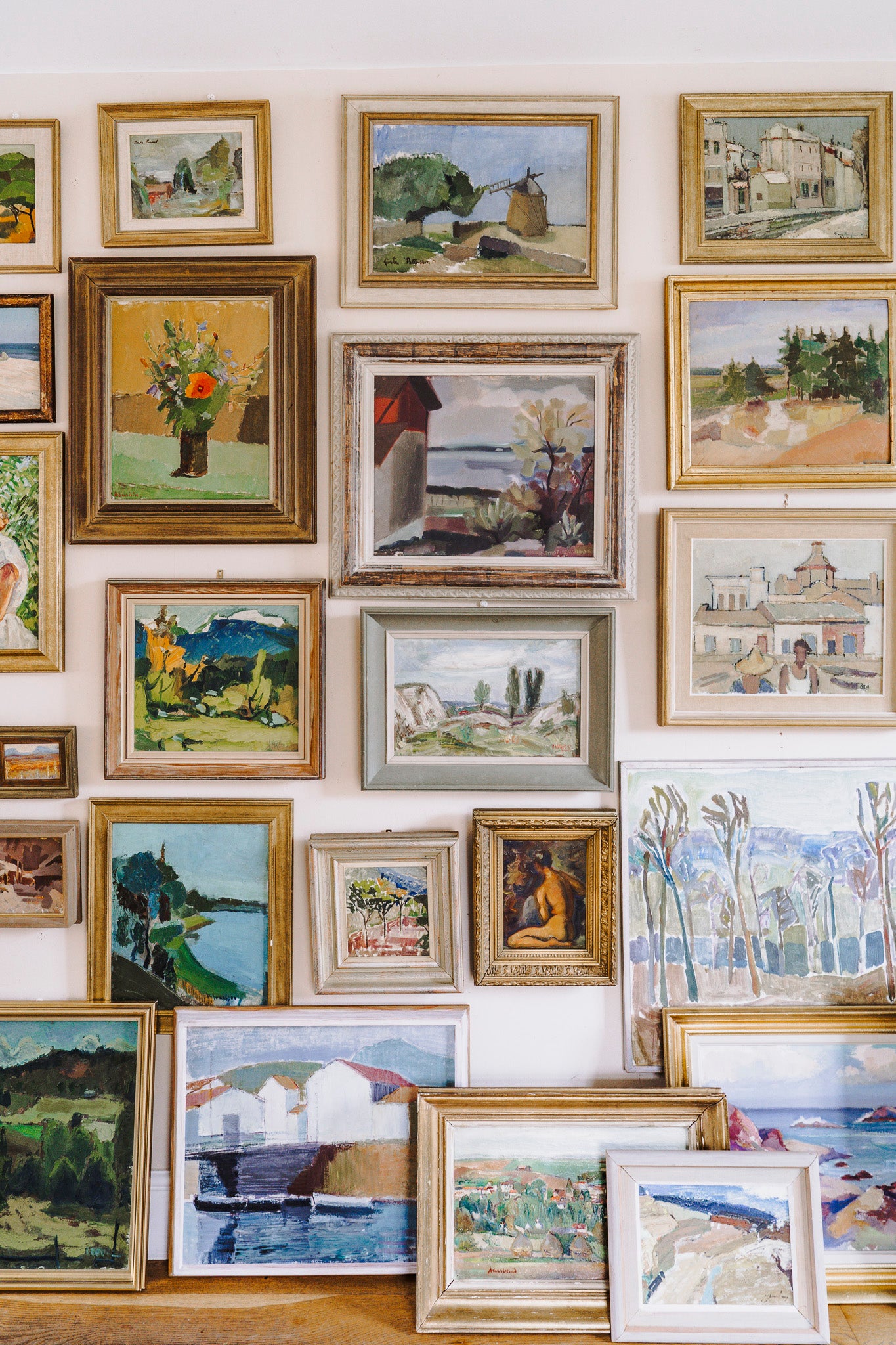 Collection of framed vintage paintings on a wall