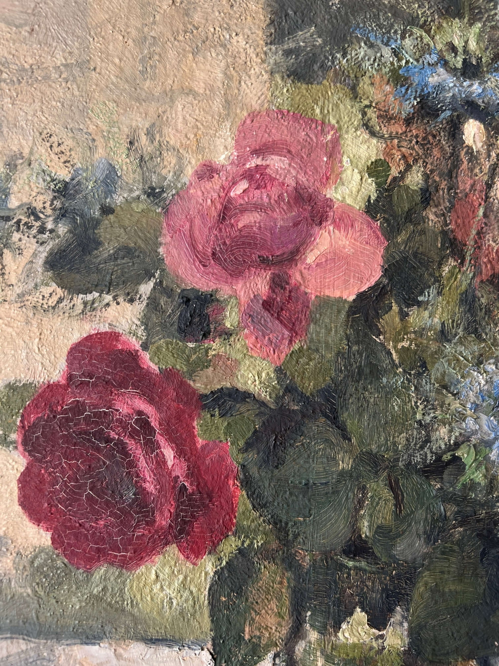 Close up of a vintage, framed oil painting of pink and blue floral. Signed by artist.