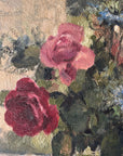 Close up of a vintage, framed oil painting of pink and blue floral. Signed by artist.
