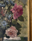 Close up of a vintage, framed oil painting of pink and blue floral. Signed by artist.