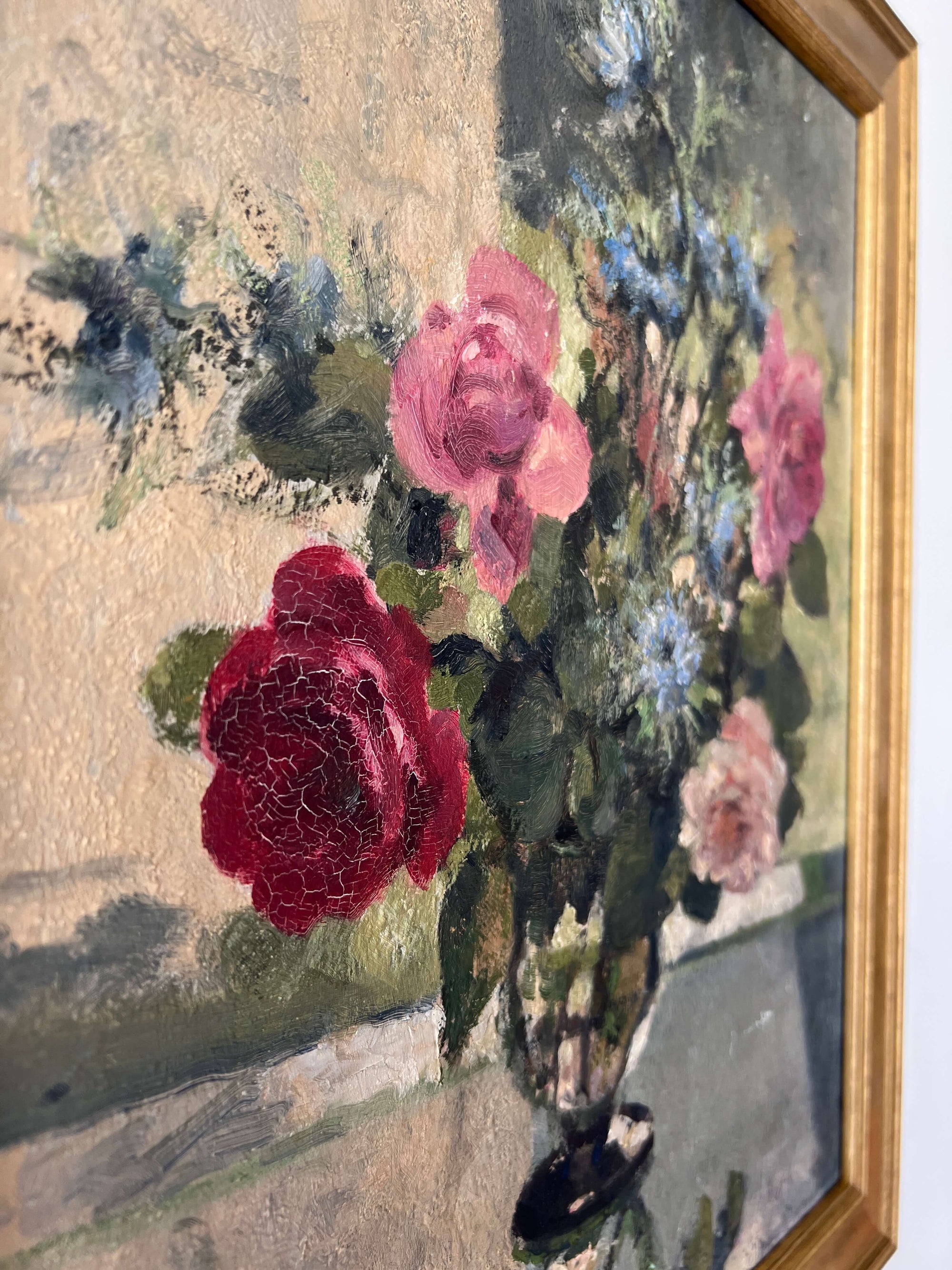 Close up of a vintage, framed oil painting of pink and blue floral. Signed by artist.