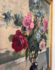 Close up of a vintage, framed oil painting of pink and blue floral. Signed by artist.
