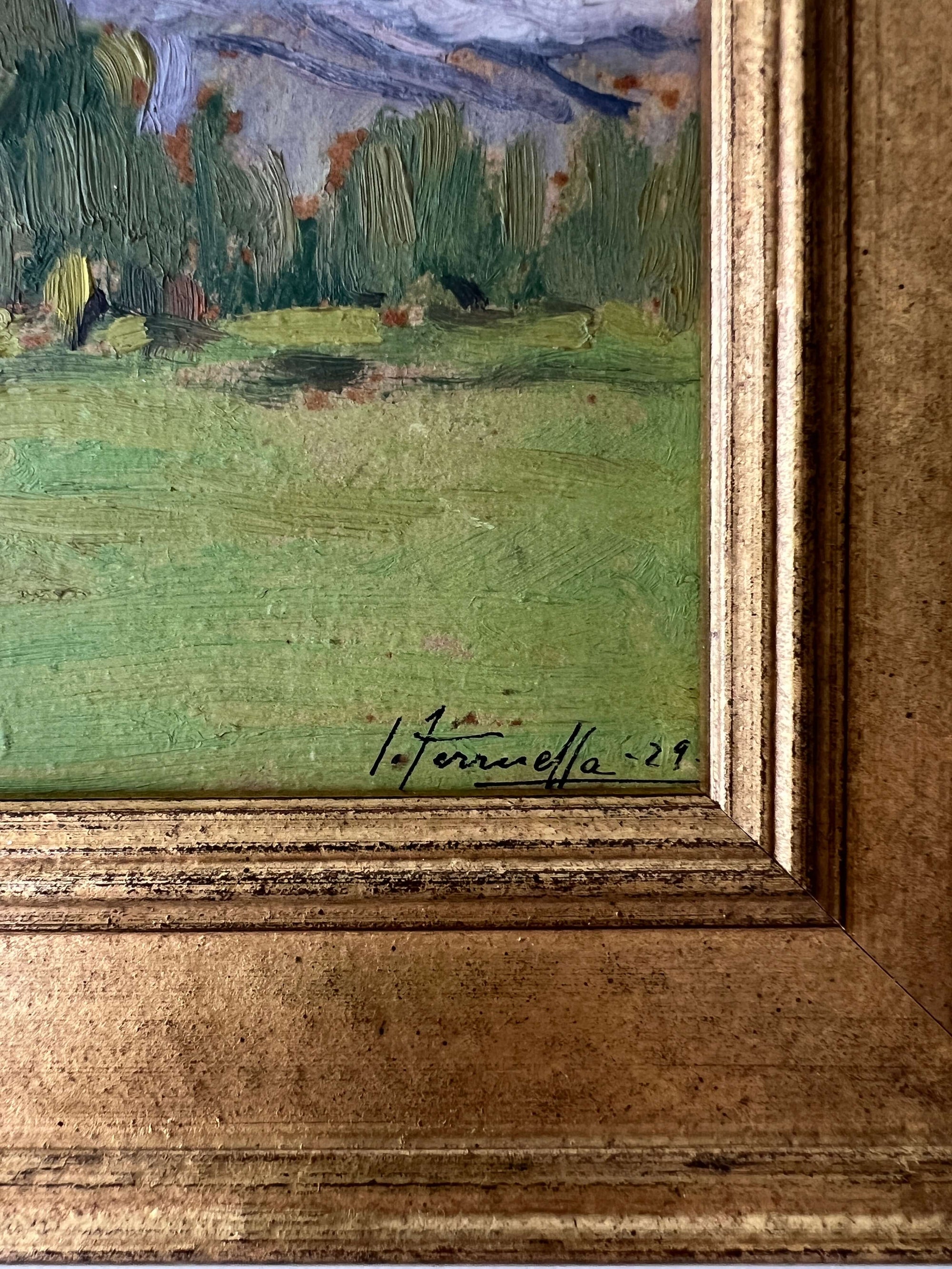 Close up of a framed vintage oil painting of a landscape with trees and a meadow.