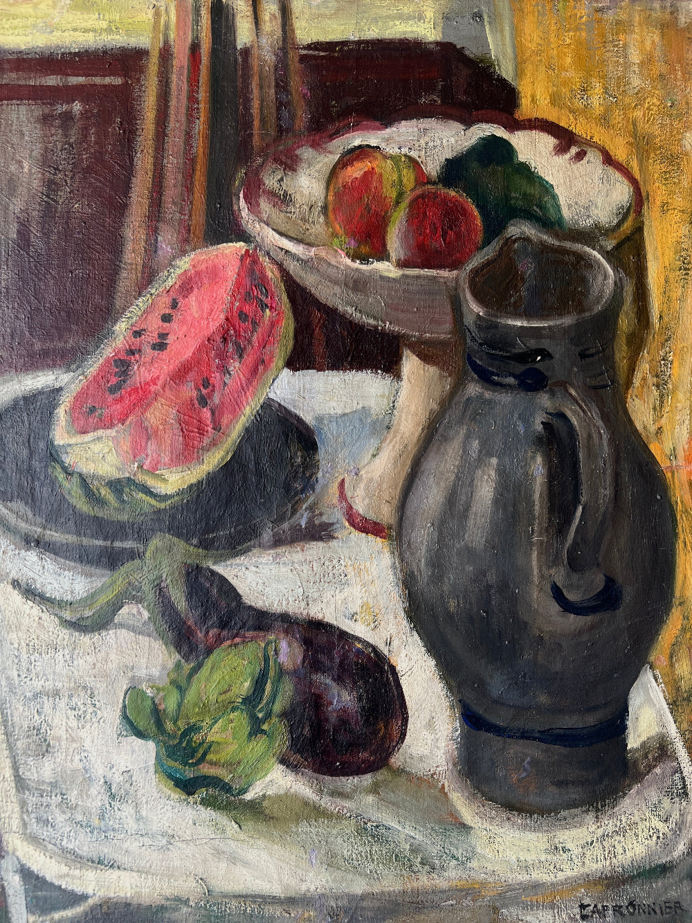 Close up of a framed still life oil vintage painting with watermelon, fruit, and jug on a table.
