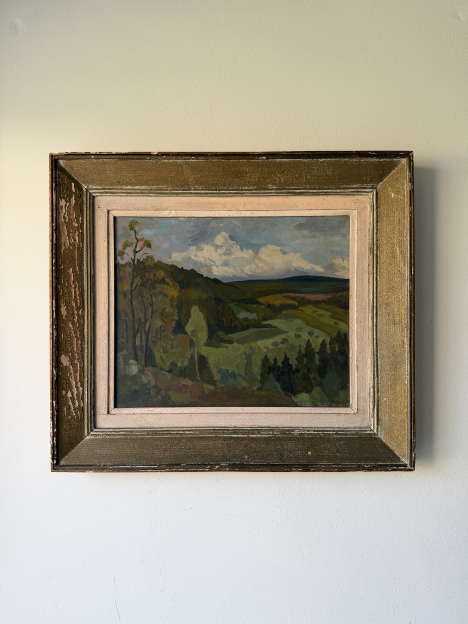 A framed vintage landscape oil painting depicting rolling green hills, trees, and a cloudy blue sky. Available at Hue. 
