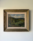 A framed vintage landscape oil painting depicting rolling green hills, trees, and a cloudy blue sky. Available at Hue. 