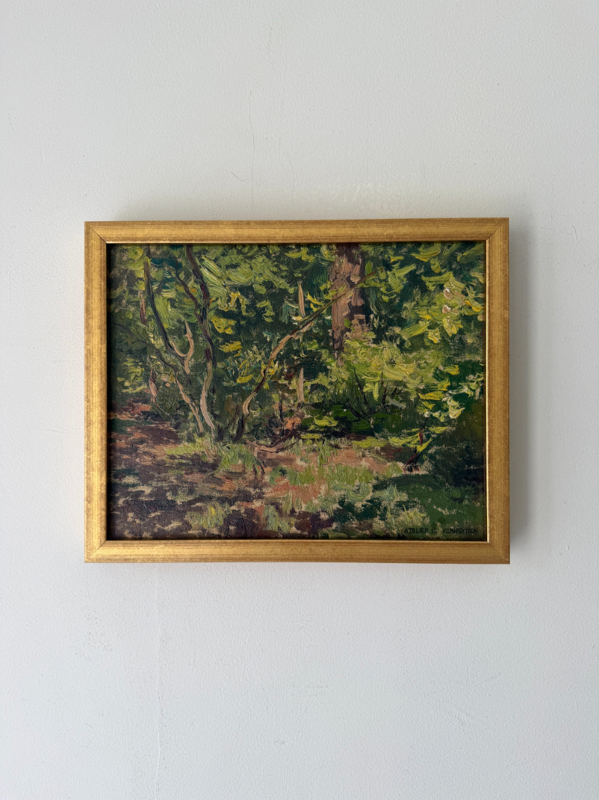 A framed vintage landscape oil painting depicting a lush green forest with trees and sunlight, enclosed in a gold frame. Available at Hue. 