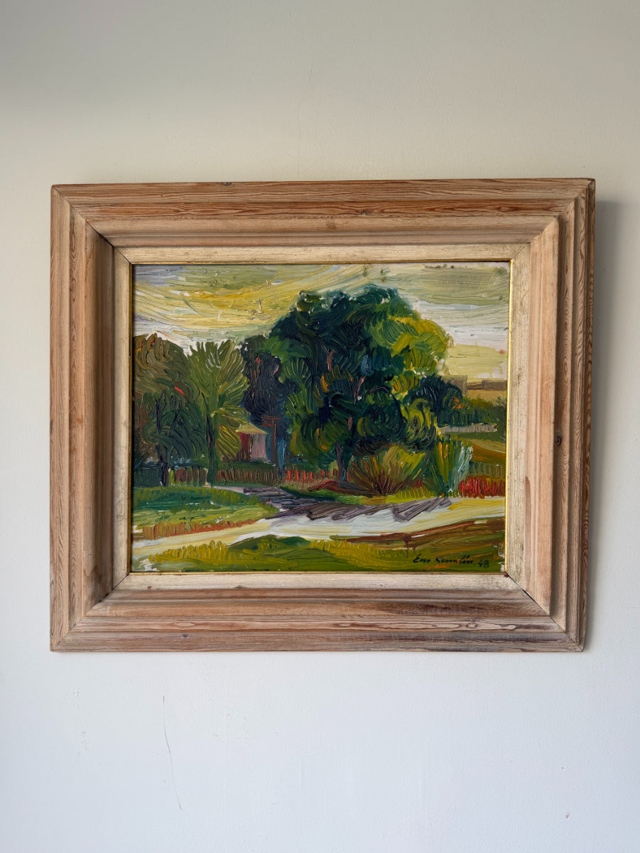 A framed vintage landscape oil painting featuring a prominent green tree, grassy fields, and a winding light-colored path under a yellow and blue sky, housed in a rustic, weathered wooden frame. Available at Hue. 